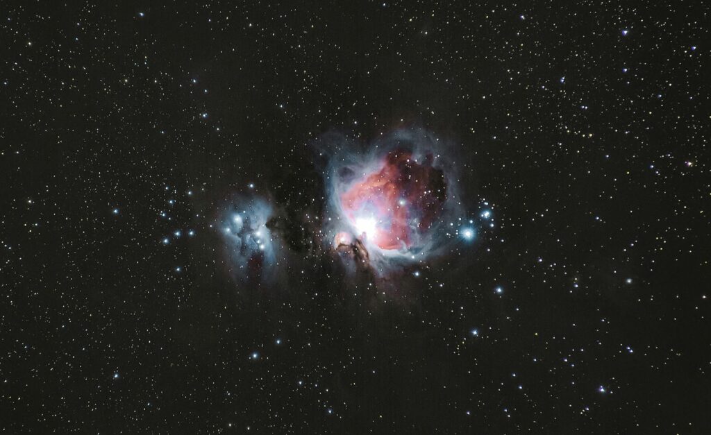 A breathtaking photograph of the Orion Nebula amidst a starry night sky, capturing celestial beauty.